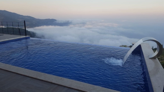 Denizle bütünleşen infinity havuz manzarası Faralya villa bulut