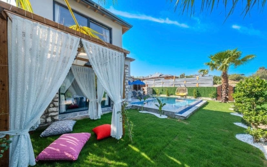 Villa İlkay 2 Seydikemer Çobanlar’da şık bahçe oturma alanı ve havuz başı dinlenme köşesi