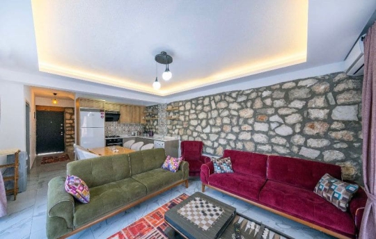 Villa İlkay 2’de modern ve konforlu salon tasarımı, taş duvar detaylarıyla şık iç mekân