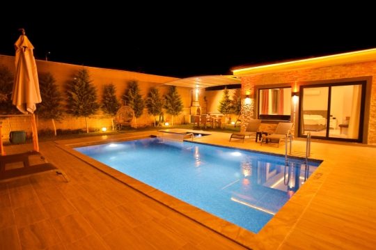 Villa Sole’un çocuk havuzlu geniş bahçesi, şezlong alanı ve doğa ile iç içe sakin atmosferi