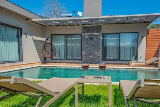 Villa Gardenella’nın özel yüzme havuzu, şezlong alanı ve çocuklu ailelere uygun geniş bahçe tasarımı.