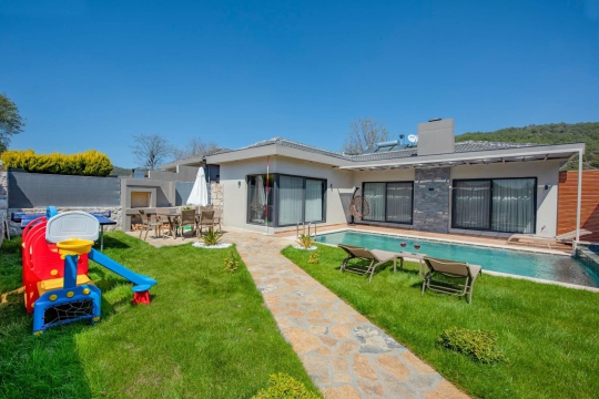 Kayaköy’de doğa içerisinde yer alan Villa Gardenella’nın korunaklı havuzlu lüks villa konsepti ve bahçe alanı.