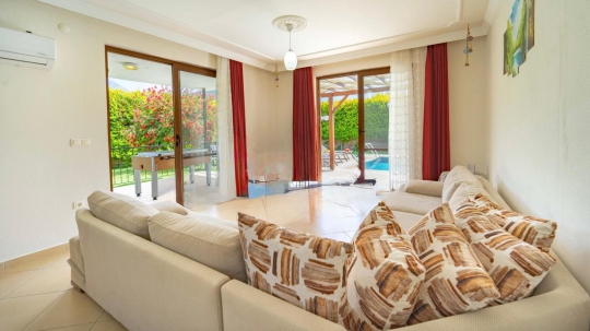 Villa Azure Mio’nun havuz manzaralı ferah salon ve oturma alanı