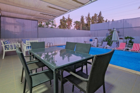 Villa Hank’in havuz manzaralı oturma alanı ve modern bahçe tasarımı