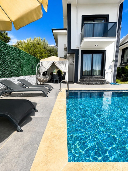 Villa Ekvator 1 Fethiye Ovacık’ta korunaklı havuz başı oturma alanı ve lüks tatil konsepti