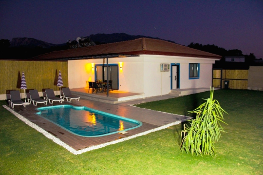 Villa Elmas 1’in geniş bahçesi ve özel yüzme havuzuyla muhafazakar ailelere uygun sakin tatil imkanı.