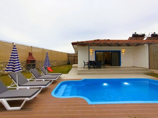 Villa Elmas 2’nin özel yüzme havuzu ve ferah bahçe alanıyla ailelere uygun konforlu tatil villası.