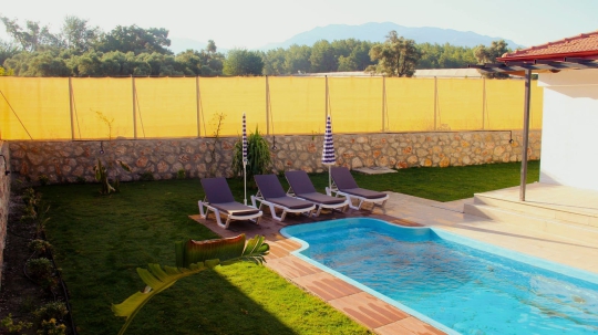 Fethiye Korubükü’nde yer alan Villa Elmas 2’nin güneş alan havuz terası ve sakin doğa atmosferi.