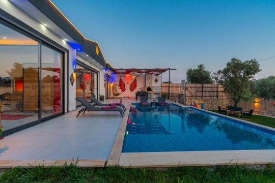Kalkan’da yer alan Villa Tawny 1’in korunaklı havuz alanı ve şık veranda tasarımıyla konforlu konaklama deneyimi.