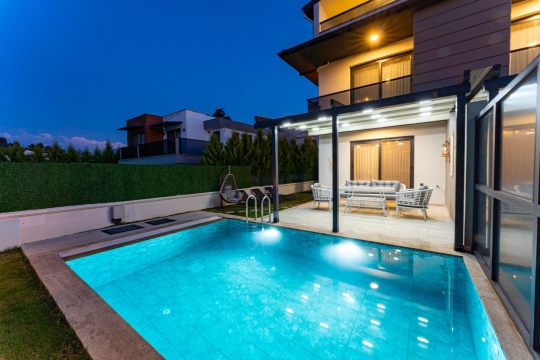 Villa Menteş 1’in özel havuzu ve modern tasarımlı bahçe alanıyla keyifli akşam atmosferi.