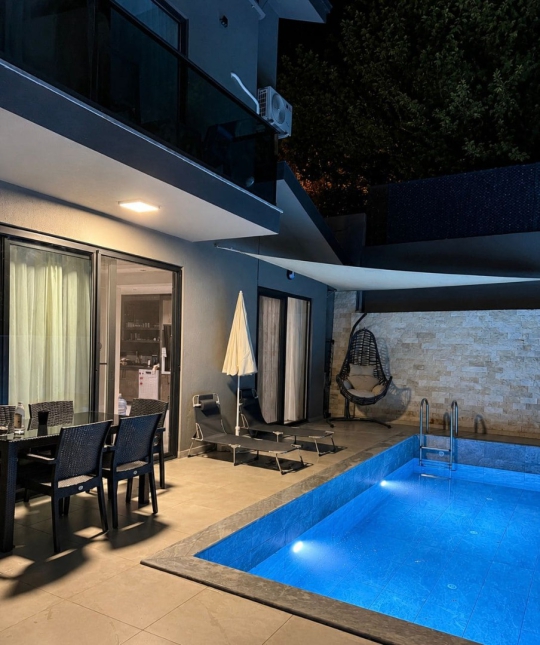 Gece ışıklandırmalarıyla şık bir atmosfer sunan Villa Ares havuz terası – Fethiye’de lüks ve modern villa tatili için ideal seçenek.