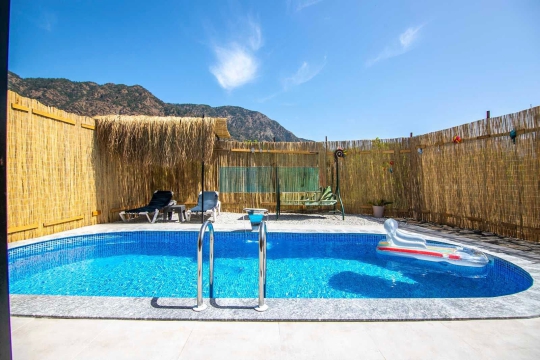 Villa Çıtak’ın geniş havuz terası ve güneşlenme alanıyla konforlu yaz tatili fırsatı.