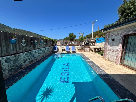Özel yüzme havuzunun geniş açıdan görünümü. Doğa ile iç içe konumu sayesinde huzurlu ve sakin bir tatil deneyimi sunmaktadır.