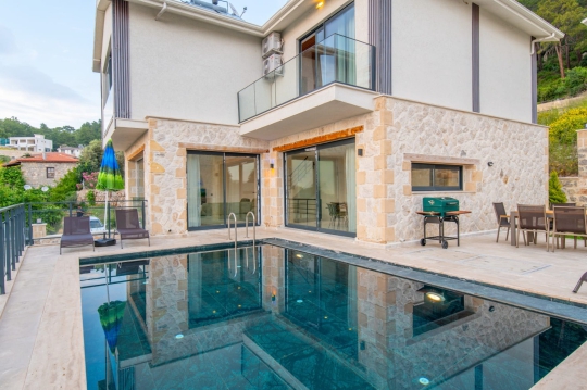 Fethiye’de bulunan Prestige 2 Villa’nın geniş havuz terası ve konforlu açık yaşam alanı.
