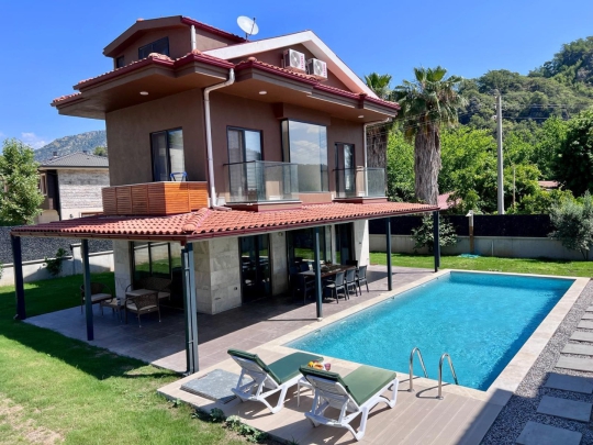 Villa Novaria’nın Göcek İnlice’de bulunan özel havuzlu ve geniş bahçeli dış cephesi, kalabalık aileler için konforlu tatil imkânı sunmaktadır.