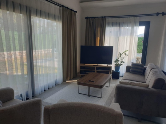 Modern dekorasyona sahip salon alanı; TV, oturma grubu ve geniş pencereleriyle ferah bir kullanım sağlamaktadır.