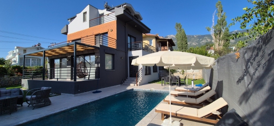 Fethiye Ovacık Villa Twins 23, modern dış cephesi, özel havuzu ve havuz başı dinlenme alanlarıyla aile tatiline uygun bir villadır.