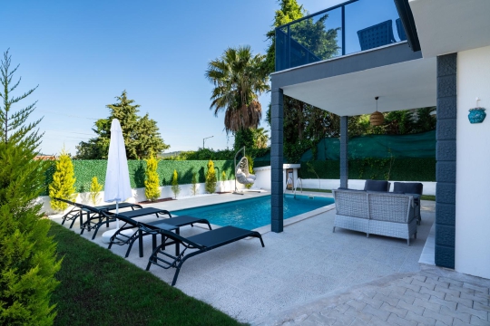 Fethiye Ovacık'taki Villa Yeşilyurt'un özel havuzu, güneşlenme alanı ve geniş bahçesiyle konforlu villa tatili.