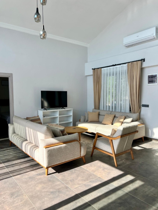 Fethiye Faralya'da bulunan Villa Kresivaya Duo 1'in modern oturma alanı, geniş salonu ve doğal ışık alan yaşam alanı.
