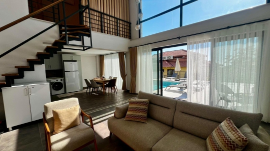 Villa Kresivaya Duo 1'in yüksek tavanlı, ferah salonu ve açık plan yaşam alanıyla Fethiye Faralya'da lüks villa deneyimi.