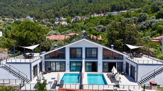 Villa Kresivaya Duo 2'nin Fethiye Faralya'da doğa ve deniz manzarası eşliğinde yükselen modern villa dış görünümü.