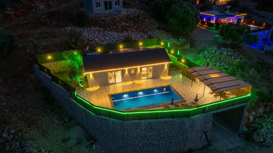 Villa Roze'nin gece ışıklandırmalarıyla öne çıkan özel havuzlu ve doğa içerisindeki şık villa görünümü.