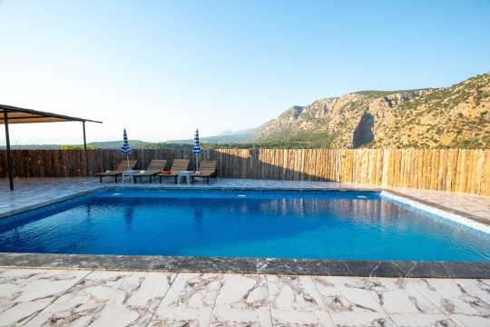 Villa Roze'nin özel yüzme havuzu ve doğa manzarası eşliğinde huzurlu tatil keyfi sunan bahçe alanı.
