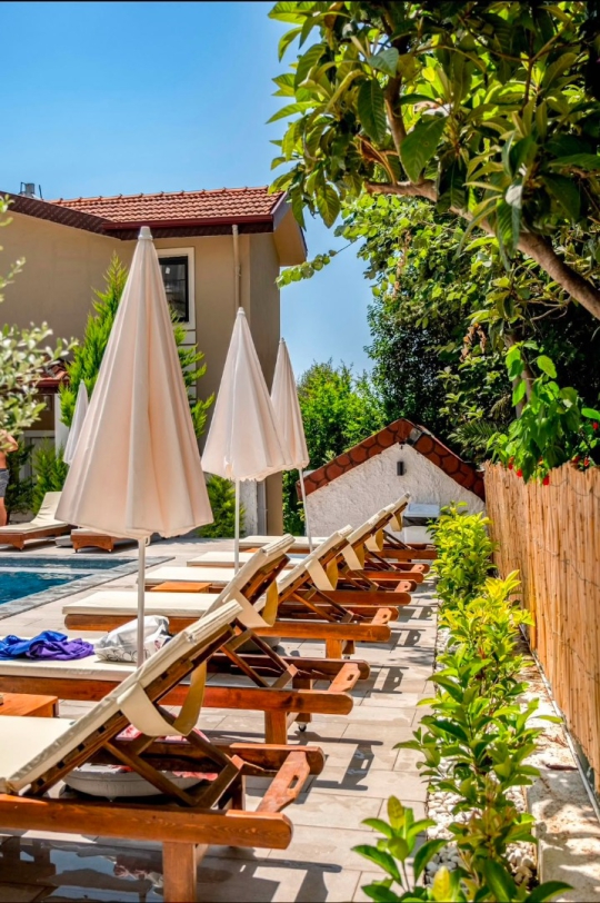 CESİ APART 103'ün havuz başındaki şezlongları ve güneşlenme alanıyla keyifli tatil atmosferi.