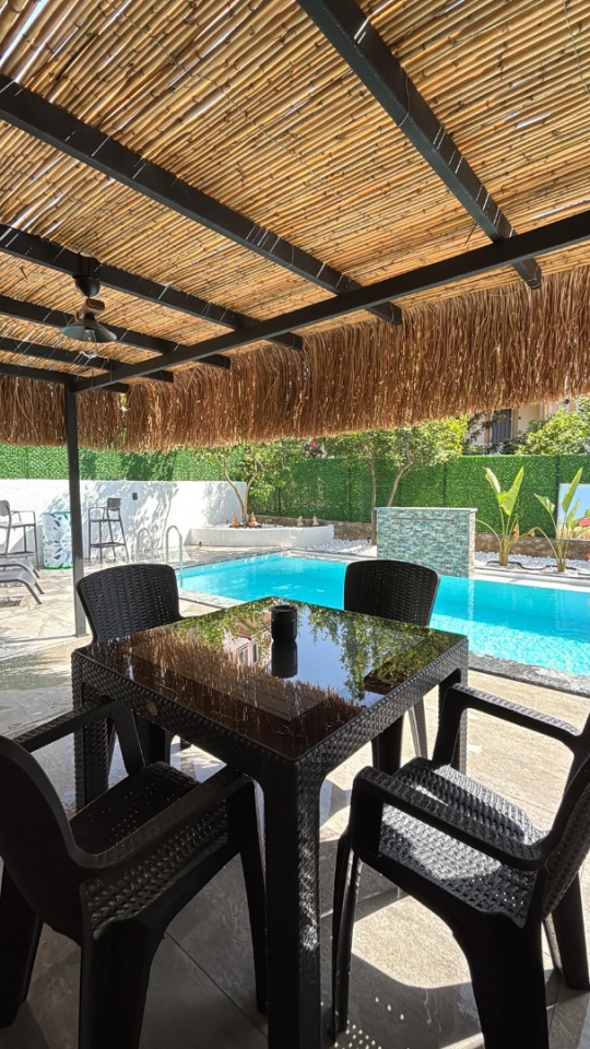 Royal Bungalov'un havuz başındaki gölgelikli oturma alanı, Fethiye'de konforlu ve dinlendirici bir tatil deneyimi sunar.