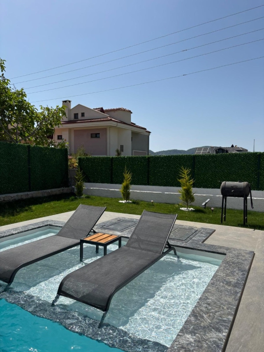 Royal Bungalov'un özel havuzu, şezlongları ve yemyeşil bahçesiyle Ovacık'ta huzurlu villa tatili sizi bekliyor.