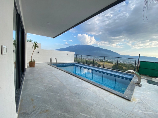Villa Pınar'ın Fethiye manzarasına hakim korunaklı havuzu ve geniş verandası balayı çiftleri için ideal bir atmosfer sunuyor