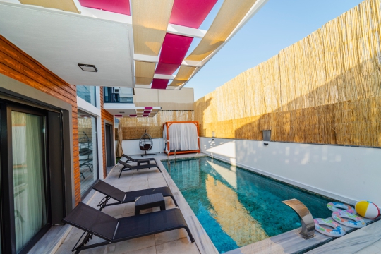 Villa Serena'nın şezlonglu özel havuzu ile konforlu açık yaşam alanı.