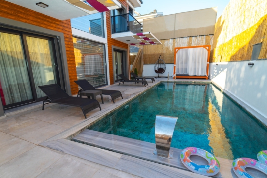 Fethiye'de kiralık Villa Serena'nın geniş özel havuzu ve dinlenme köşesi.