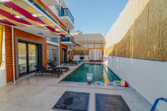 Villa Serena'nın özel yüzme havuzu, güneşlenme terası ve modern dış mekân tasarımı.