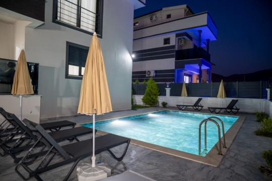 Villa Momo Dalaman Merkez'de akşam aydınlatmalı özel havuzu ve modern tasarımıyla lüks villa tatili deneyimi sunmaktadır.