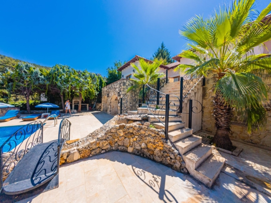 Villa Macha Kalkan'da taş bahçe düzenlemesi, geniş bahçesi ve bohem mimarisiyle doğa içinde lüks villa deneyimi sunuyor.