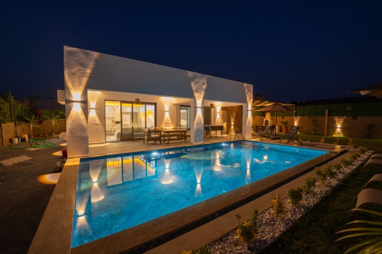 Villa Tommy'nin gece ışıklandırmalı özel havuzu, muhafazakar bahçesi ve modern mimarisiyle unutulmaz bir villa deneyimi sunuyor.