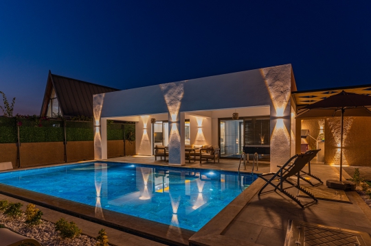 Fethiye Çalıca'da yer alan Villa Tommy'nin özel yüzme havuzu ve modern mimarisiyle öne çıkan muhafazakar lüks villa görünümü.