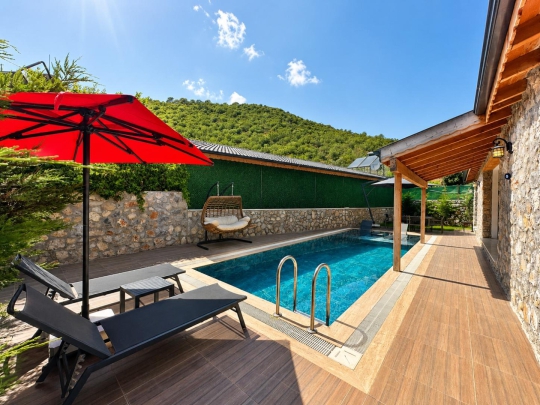 Villa Tint Duo'nun özel yüzme havuzu, güneşlenme alanı ve huzurlu doğa manzarasıyla keyifli tatil ortamı.