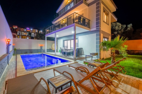 Villa Voi'nun gece ışıklandırmalı özel havuzu, geniş terası ve modern mimarisiyle ailelere ve balayı çiftlerine uygun yaşam alanı.