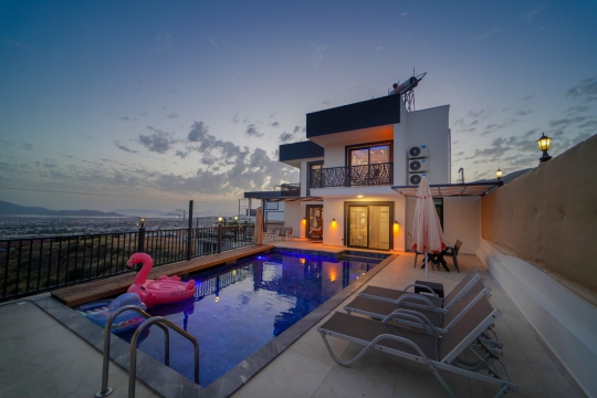 Gün batımında ışıklandırılan özel havuzu ve modern tasarımıyla Villa Holly, Fethiye Karaçulha'da unutulmaz bir villa tatili sunmaktadır.