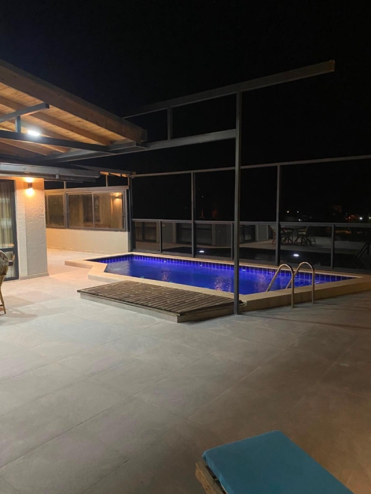 Akşam ışıklarıyla şık bir atmosfere kavuşan Villa Tarla'nın özel havuzu, aileler ve arkadaş grupları için keyifli bir konaklama imkânı sağlamaktadır.