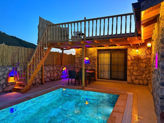 Villa Soho’nun Fethiye Kayaköy’deki korunaklı özel havuzu, taş duvarlarla çevrili bahçesi ve şık dış yaşam alanından görünüm.