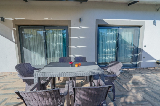 Saklıkent Tatil Evi 2'nin bahçe terası ve yemek masası. Geniş bahçeli muhafazakâr tatil evi, Seydikemer Saklıkent'te konumlanmaktadır.