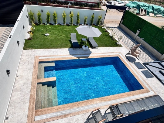 Villa Ruby 2'nin özel yüzme havuzu, geniş bahçesi ve güneşlenme alanıyla konforlu tatil sunan dış mekânı.