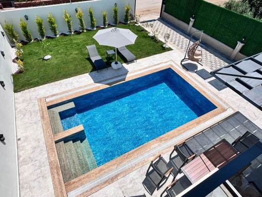 Villa Ruby 2'nin özel yüzme havuzu, şezlong alanı ve geniş bahçesiyle keyifli yaz tatili imkânı.