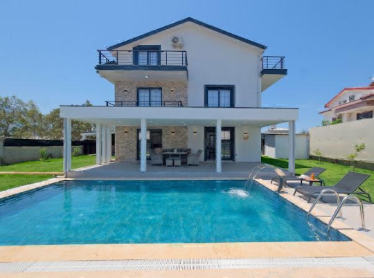 Villa Azra 2’in özel yüzme havuzu, geniş bahçe alanı ve modern mimarisiyle Fethiye Çamköy villa tatili.