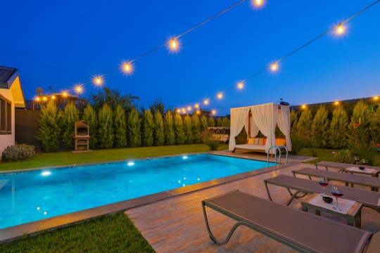 Villa Lizbon’un özel yüzme havuzu ve bahçe alanı; Patlangıç’ta aileler ve balayı çiftleri için korunaklı özel havuzlu tatil villası.