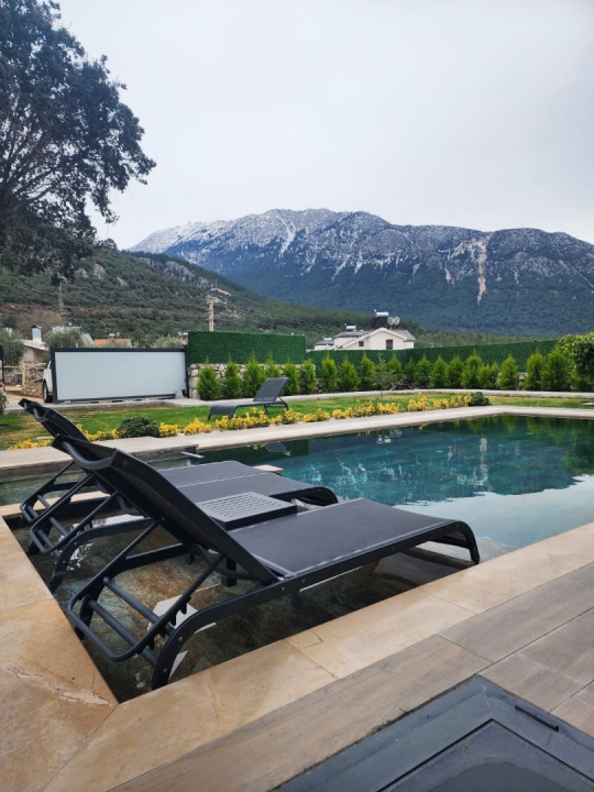 Fethiye Ovacık Villa Olea 2’nin özel havuz alanı, şezlongları ve doğa manzarasıyla huzurlu bir tatil atmosferi sunuyor.