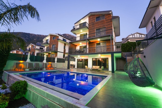 geniş özel havuzu, modern dış mimarisi ve dağ manzarası eşliğinde konforlu villa tatili.